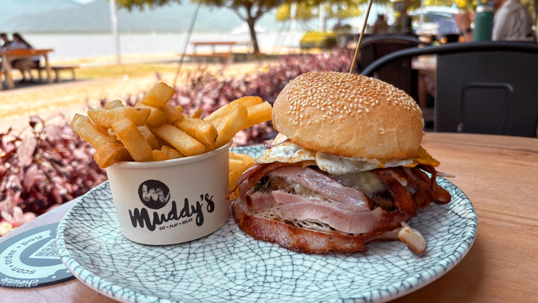 Big burger and fries from Muddy's Cafe in Cairns with water in foreground (best places to eat in Cairns).
